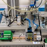 Detalhe de equipamentos industriais com fiação eletrônica e sensores em uma instalação de manufatura