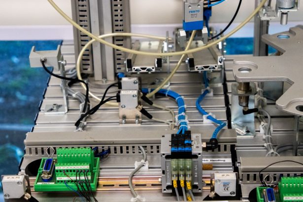 Detalhe de equipamentos industriais com fiação eletrônica e sensores em uma instalação de manufatura