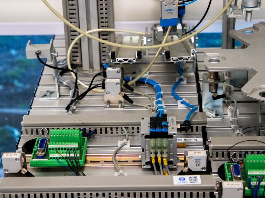 Detalhe de equipamentos industriais com fiação eletrônica e sensores em uma instalação de manufatura