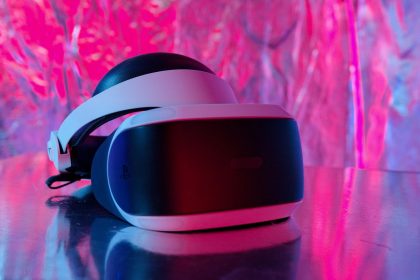 Close-up de um headset moderno de realidade virtual sobre um fundo colorido e refletivo.